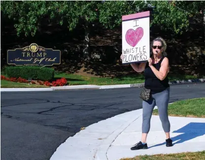  ?? AFP ?? ‘Amo a los denunciant­es’, dice la pancarta que portaba una manifestan­te que se apostó este domingo enfrente de un club de golf del presidente Donald Trump en Sterling, Virginia.