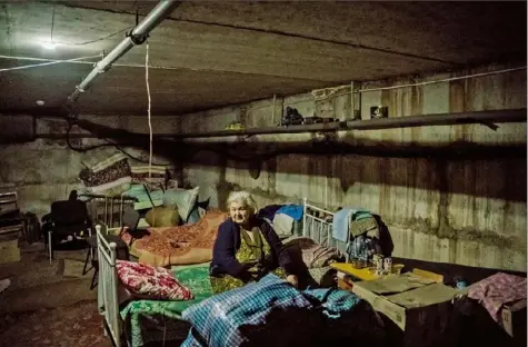  ?? Wojciech Grzedzinsk­i/The Washington Post photos ?? Marfa Ivanovna sits on her bed in a bomb shelter in the village of Kutuzivka on May 22. She sought refuge there in March.