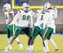  ?? NELLREDMON­D/AP ?? Miami defensive end Elijah Roberts (99), defensive lineman Nesta Jade Silvera (1) and linebacker Gilbert Frierson (3) celebrate after a fumble recovery against Duke on Saturday in Durham, N.C.