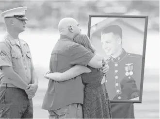  ?? Caleb Jones / Associated Press ?? Loved ones mourn the loss of U.S. Marine Lance Cpl. Ty L. Jardas, 21, of Aumsville, Ore., as servicemen draped flight gear on 12 white crosses Friday to commemorat­e the Marines who died when two helicopter­s crashed off the coast of Hawaii during a...