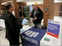  ??  ?? In this Nov. 2, 2017 photo, a recruiter from the postal service (right) speaks with an attendee of a job fair in Cheswick, Pa. The unemployme­nt rate fell to record lows in three U.S. states in December 2017, as steady hiring soaked up more of those out...