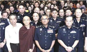  ??  ?? Fuzi (second right) and Selangor police chief Datuk Mazlan Mansor (right) in a group photo after attending a Buddhist religious programme in conjunctio­n with the 211st Police Day celebratio­n at Samadhi Vihara, Section U12. — Bernama photo