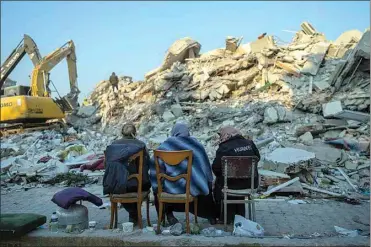  ?? BERNAT ARMANGUE / AP ?? Women sit in front of the rubble of an area destroyed during the earthquake in Antakya, southeaste­rn Turkey, Sunday.