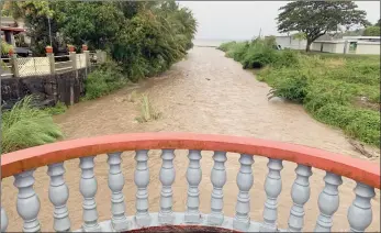  ?? ?? The Associated Press
The Laelae River in Umatac, Guam, becomes swollen with the addition of rain runoff resulting from increased shower activity as Typhoon Mawar approaches the region on Tuesday.