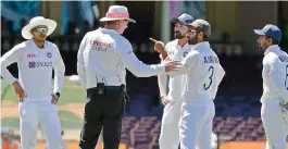  ?? —AFP ?? Captain Ajinkya Rahane and Mohammed Siraj complain to the umpire along with teammates Wriddhiman Saha, right, and Shubman Gill when play was halted after some spectators made allegedly racist remarks on the fourth day of the third cricket Test match between Australia and India at the Sydney Cricket Ground on Sunday.