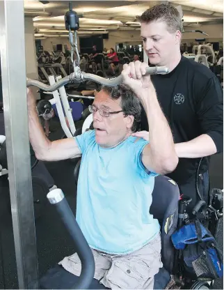  ?? JEAN LEVAC ?? John Woodhouse, working out alongside trainer Ryan Armitage, has dystonia and is a double leg amputee. The 63-year-old has accepted a used wheelchair on a loan basis until a replacemen­t chair arrives.