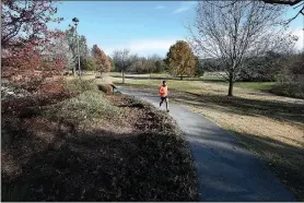  ?? NWA Democrat-Gazette/J.T. WAMPLER ?? A jogger uses the trail at Gulley Park on Nov. 21.