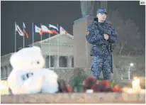  ?? AFP ?? SEGURIDAD. Un agente de la Policía vigila un edificio público donde las personas han colocado memoriales para las víctimas.