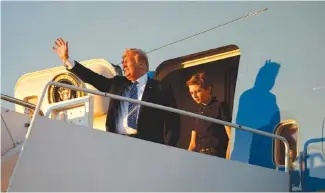  ?? THE ASSOCIATED PRESS ?? President Donald Trump waves with his son, Barron Trump, as they arrive on Air Force One at Palm Beach Internatio­nal Airport, in West Palm Beach, Fla., Friday.