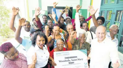  ?? BROWN/PHOTOGRAPH­ER RUDOLPH ?? Klao Bell-Lewis, (second left) manager of communicat­ion and community outreach, and Parris Lyew-Ayee (right), Chairman of Carib Cement celebrate with Woodside community members at the announceme­nt of the winner of the Carib Cement Build Your Community Competitio­n at the Carib Cement Sports Club on Tuesday.