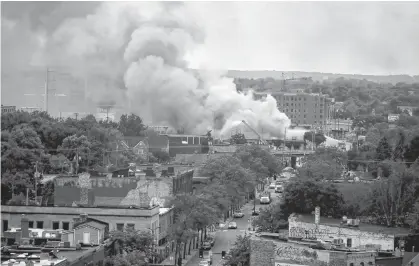  ?? REUTERS/CARLOS BARRIA ?? Plumes of smoke rise into the sky in the aftermath of a protest after a white police officer was caught on a bystander’s video pressing his knee into the neck of African-American man George Floyd, who later died at a hospital, in Minneapoli­s, Minn.