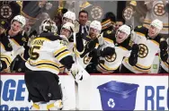  ?? RICH LAM - THE ASSOCIATED PRESS ?? Boston Bruins goalie Linus Ullmark, left, celebrates his empty-net goal against the Vancouver Canucks on Saturday.