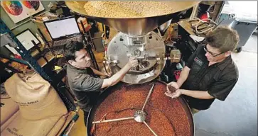  ?? Al Seib Los Angeles Times ?? CHUCK JONES, right, with master roaster Raphael Batiz as they prepare coffee beans in their Pasadena location. Most of their beans come from a Guatemalan farm that has been in Jones’ family since 1870.