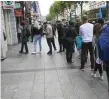  ??  ?? Customers queue at an ATM on O’Connell Street in Dublin last night