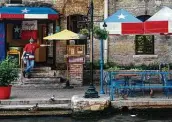  ?? Billy Calzada / Staff photograph­er ?? A waiter awaits customers at the Republic of Texas restaurant on the River Walk in August.