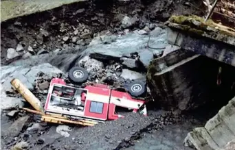  ??  ?? Un ponte crollato e un mezzo dei vigili del fuoco nel greto di un torrente a Gosaldo, nel Bellunese: salvi i pompieri