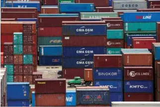  ?? REUTERS ?? SHIPPING CONTAINERS are seen stacked up at a port in Shanghai in this July 10 file photo.