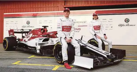  ?? REUTERS PIC ?? Alfa Romeo’s Kimi Raikkonen (left) and Antonio Giovinazzi with the new car.