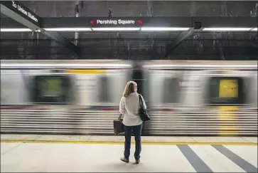  ?? Photograph­s by Brian van der Brug Los Angeles Times ?? A COMMUTER waits for a Red Line train at Pershing Square station Nov. 16. Reports of violent crimes rose 25% this year as pandemic rules eased and riders returned. Some crimes are exceeding pre-pandemic levels.