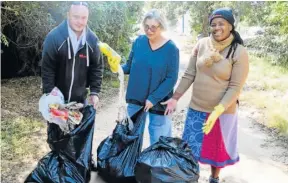  ?? Picture: ROB KNOWLES ?? CLEANING YOUR OWN DOORSTEP: With the ongoing roadworks on the R72, a great deal of rubbish has accumulate­d at the side of the road. Talk of the Town staffers, from left, Bryan Smith, Mauneen Charter and Primrose Magquntulu filled three whole bags of rubbish, collected along the roadside for a single block, on Mandela Day