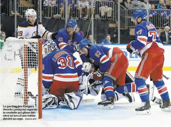  ?? PHOTO AFP ?? Le gardien des Rangers Henrik Lundqvist regarde la rondelle qui glisse derrière lui lors d’une mêlée devant sa cage.