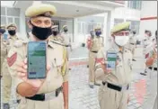  ?? ANI ?? Policemen display the Aarogya Setu app in J&K’S Reasi.