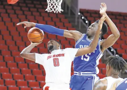  ?? ETHAN HYMAN/ASSOCIATED PRESS ?? Duke’s Mark Williams tries to block the shot of North Carolina State’s D.J. Funderburk on Saturday in Raleigh, North Carolina. Williams, a former Norfolk Academy star, finished with 13 points and five blocked shots.