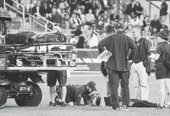  ?? CANADIAN PRESS FILE PHOTO ?? Coaching staff and players gather around Argonauts quarterbac­k Ricky Ray, who was injured Saturday against the Calgary Stampeders at BMO Field in Toronto.