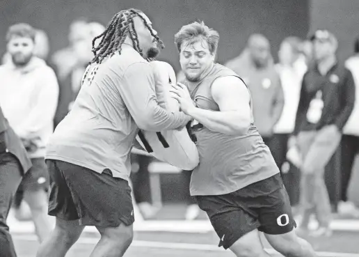  ?? BEN LONERGAN/THE (EUGENE, ORE.) REGISTER-GUARD ?? Oregon’s Jackson Powers-Johnson, right, is part of a deep and talented group of centers in the draft.