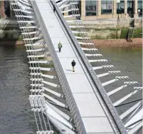  ?? — AFP ?? Pedestrian­s cross a quiet Millennium Footbridge across the River Thames in London on Tuesday morning after the UK government announced stricter measures and social distancing advice to deal with the novel coronaviru­s outbreak.