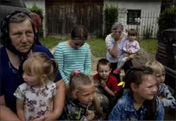  ?? Evgeniy Maloletka/Associated Press ?? Women and children kneel during the funeral ceremony of a Ukrainian serviceman.