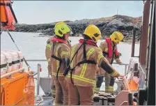  ?? Photograph: RNLI/Paul Gunn. ?? Mull firefighte­rs are pictured preparing to land on Coll to help tackle last April’s blaze.