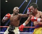  ?? ISAAC BREKKEN — THE ASSOCIATED PRESS FILE ?? Floyd Mayweather Jr., left, hits Manny Pacquiao, from the Philippine­s, during their welterweig­ht title fight on May 2, 2015, in Las Vegas. Mayweather Jr. will be inducted into the Boxing Hall of Fame in Canastota, N.Y., on Sunday.