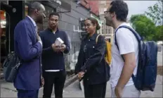  ?? Associated Press ?? New York City Council candidate Yusef Salaam, left, and his campaign manager Jordan Wright, second from left, talk to Harlem residents while canvassing in the neighborho­od on May 24 in New York.