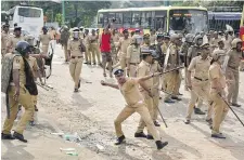  ??  ?? A policeman throws back a stone as officers clash with protesters near the Sabarimala temple on Wednesday.