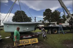  ?? The New York Times/VICTOR J. BLUE ?? Jeff Coppersmit­h (from left), Arthur Nichols and Katie Fielder load a fiberglass pool to move it out of Grandy, N.C., on Tuesday as Hurricane Florence moves closer to the region.