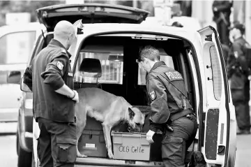  ??  ?? Police checks a car with a sniffer dog at an entrance of the court before the start of a trial of five suspected Islamist militants in Celle, Germany. — Reuters photo