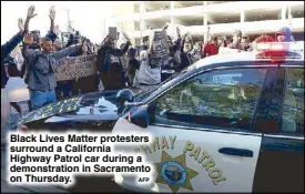  ?? AFP ?? Black Lives Matter protesters surround a California Highway Patrol car during a demonstrat­ion in Sacramento on Thursday.