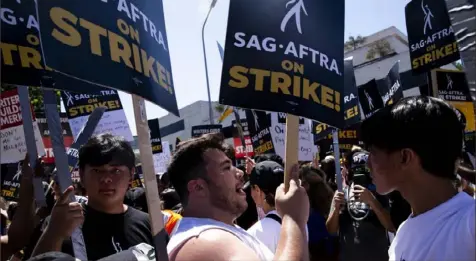  ?? Jenna Schoenefel­d/The New York Times ?? Striking members of SAG-AFTRA, the actors’ union, picket Aug. 4 outside Universal Studios in Los Angeles. Actors have been on strike since July, with many of the same demands as the writers’.