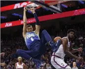  ?? CHRIS SZAGOLA — THE ASSOCIATED PRESS ?? The Mavericks’ Kristaps Porzingis dunks over the 76ers’Joel Embiid for two of his 22points in Friday’s win. The Mavericks handed the Sixers their third straight loss.