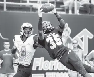  ?? DANIEL A. VARELA Daniel A. Varela ?? Florida Internatio­nal University cornerback Rishard Dames intercepts the pass intended for Marshall University wide receiver Tyre Brady. Brady, a former UM receiver, caught two touchdowns Saturday.