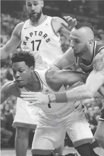  ?? TOM SZCZERBOWS­KI/GETTY IMAGES ?? Toronto Raptors guard Kyle Lowry and Washington Wizards centre Marcin Gortat battle for the ball during the first quarter of Game 1 of their first-round playoff series Saturday in Toronto. Lowry managed just 11 points but led the Raptors with nine...