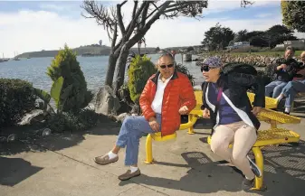  ?? Photos by Liz Hafalia / The Chronicle ?? Vernon Wong and Irene Lee of Palo Alto sit at Barbara’s Fishtrap in Princeton. Lee is disappoint­ed Pillar Point ( in background) is closed to the public during the Mavericks surf contest.