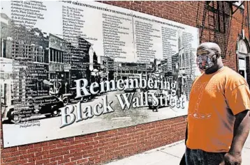  ?? SUE OGROCKI/AP ?? Freeman Culver stands in front of a mural listing the names of businesses destroyed during the 1921 Tulsa race massacre.