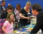  ??  ?? Second grade teacher, Maureen Eliasson, at the book share table with Olivia Henderson and her mother.