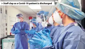  ??  ?? > Staff clap as a Covid-19 patient is discharged