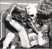  ??  ?? BOBBY ALLISON, left, fights Cale Yarborough after taking a helmet to the face following the race.
