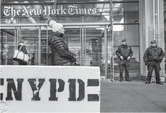  ?? Drew Angerer / Getty Images ?? Police guard the offices of the New York Times in Manhattan as security is ramped up around the city after bombs addressed to critics of President Donald Trump were intercepte­d.