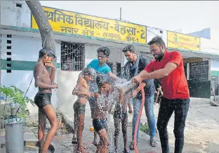  ?? PHOTOS: DEEPAK GUPTA ?? Students being given a shower by volunteers of Innovation For Change, in primary school Behsa2 on Saturday.