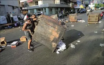  ?? Hussein Malla Associated Press ?? SUPPORTERS OF Prime Minister-designate Saad Hariri block streets in Beirut last week after he and other leaders failed to agree on a government and he resigned. The Lebanese lira plunged in value on the news.